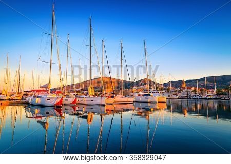 Trogir Cityscape With Sailing Boats In The Harbor At Dawn. Beautiful Travel And Touristic Destinatio