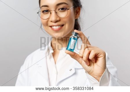 Close-up Portrait Of Young Professional Asian Doctor, Researcher Or Infectionist, Giving Patient Amp