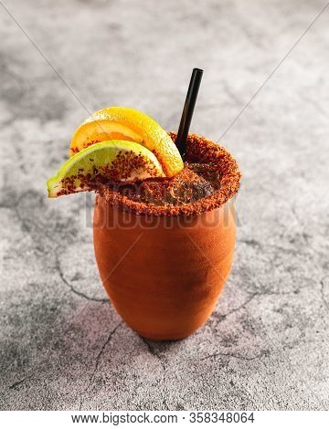 Traditional Mexican Alcoholic Drink In Terra Cota Cup With Spices Orange Lime On Cups Rim