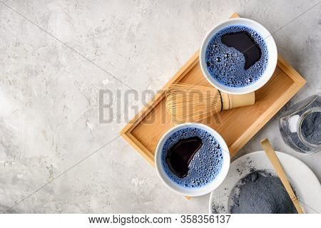 Blue Matcha Tea In Two White Cup , Wooden Tray, Bamboo Tavan And Tasaku, Powder On White Gray Backgr