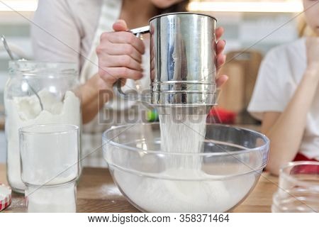 Close-up Sifting Flour Through Metal Sieve Cup.