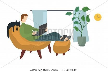 A Man In An Upholstered Chair Works With A Laptop In A Home Environment. Comfortable Remote Work