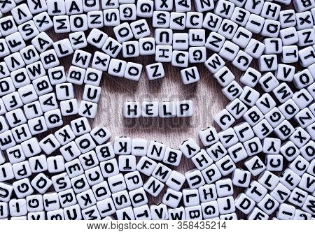 Word Help Written In English With Square White And Black Letters Mixed Up With All The Alphabet Lett