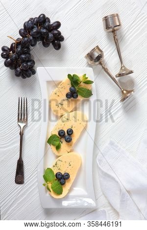Halumi Cheese With Blueberries And Grapes On A White Plate With Vintage Accessories. View From Above