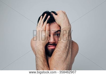 Young Man Isolated Over Background. Portrait Of A Worried Guy Covering Face With Hands. Madness And 