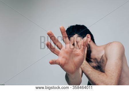Young Man Isolated Over Background. Stressful Confused Guy Show Hand And Try To Hide Form Camera. Al