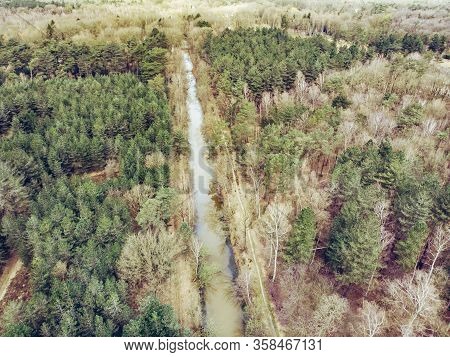 Aerial Drone Shot, Of A Forest With River Or Canal Running Through In Early Spring. Location: Antita
