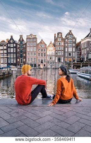 Amsterdam Damrak During Sunset, Happy Couple Man And Woman On A Summer Evening At The Canals