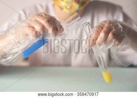 A Child In A White T-shirt In The Laboratory Is Studying Chemistry . Young Scientists In Protective 