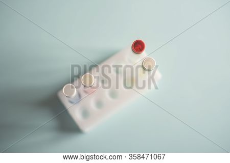 Glass Medical Flasks, Jars With Chemicals And A Yellow Daffodil Flower On A Light Background