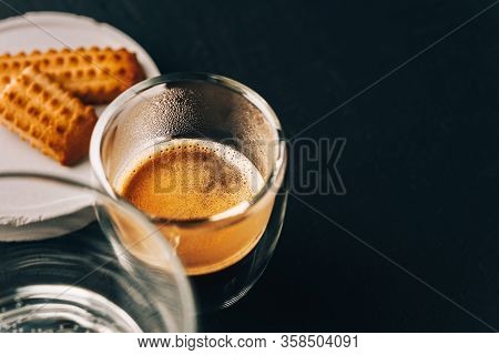 One Portion Of Espresso In Glass Transparent Cups, Bisuits And Water On A Dark Stone Background, Cop