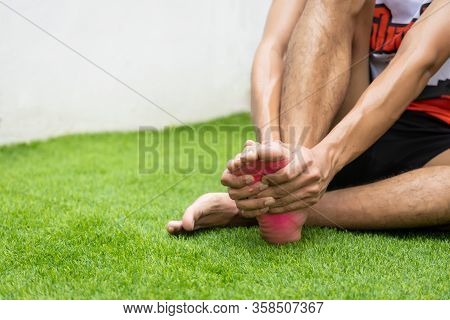 Close Up On Foot Sole Injury. The Man Use Hands Hold On His Foot Sole While Running.