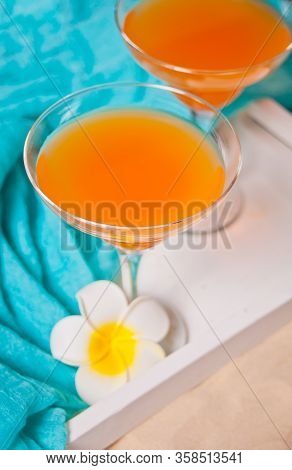Glasses Of Tropical Exotic Multifruit Juice Cocktail Drink On The White Tray With Plumeria Frangipan