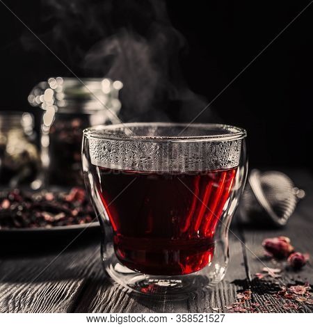 Cup Of Freshly Brewed Red Karkade Tea, Rose Tea Ceremony, Dark Moody.hot Water Is Poured From The Ke
