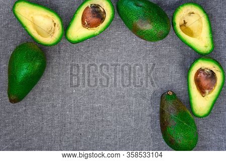 Opened Avocado Showing Seed On Textured Grey Linel Background. Top View, Copy Space, Organic Healthy