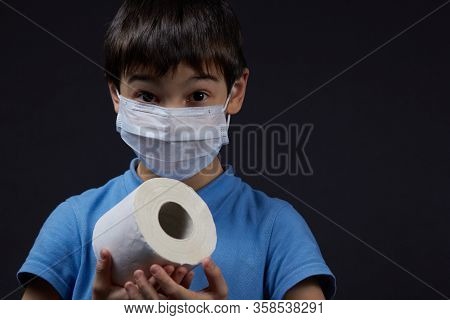 A Child In A Protective Mask Holding Toilet Paper Napkins