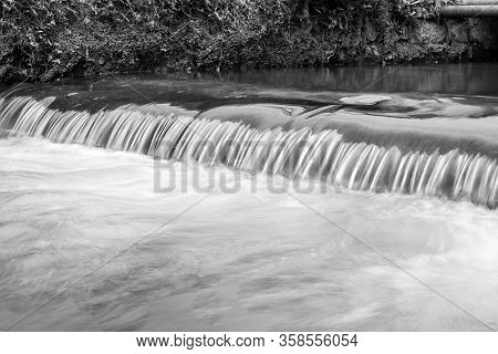 Long Exposure Of A Watefall On The River Lim Walkway At Lyme Regis In Dorset.