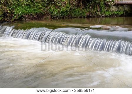 Long Exposure Of A Watefall On The River Lim Walkway At Lyme Regis In Dorset.