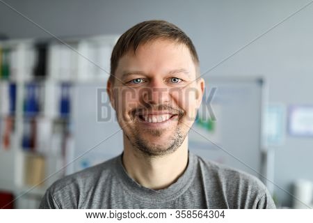 Unshaven Man In T-shirt Stands At Home And Smiles. Sit At Home And Relax. Take Breath Before New Wor