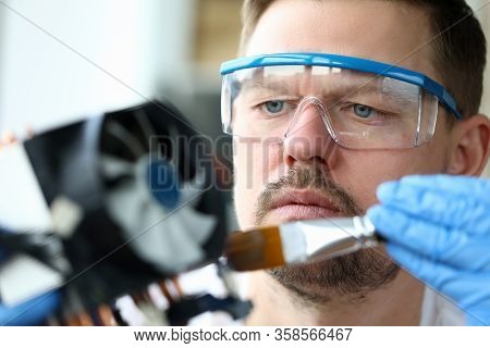 Close-up Man Goggles Mends Mechanical Part Device. Replacement Thermal Paste Processor, Lubrication 