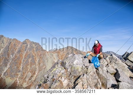 Man Hiker Picking Up Litter In Nature In Mountains, Plogging Concept.