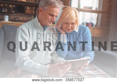 Portrait Of Pensioners Watching Movie On Tablet And Using Headph