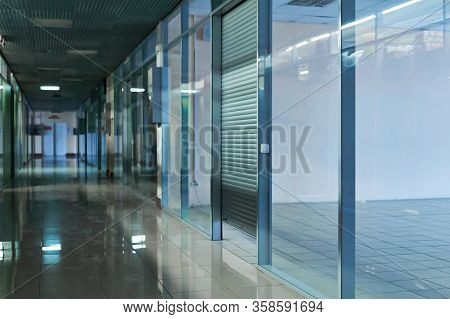 Blurred Dim Dark Deserted Mall Corridor With Empty Retail Space Without Tenants