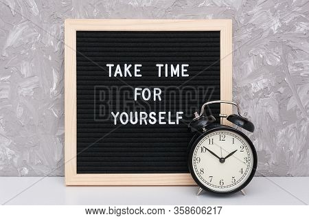Take Time For Yourself. Motivational Quote On Letterboard And Black Alarm Clock On Table Against Sto