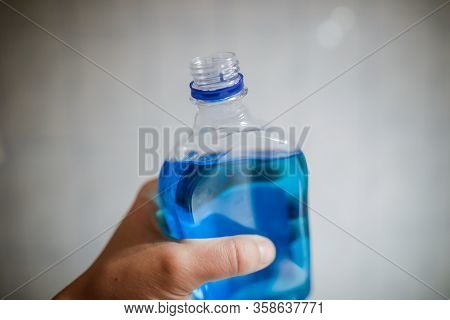 Shallow Depth Of Field Image (selective Focus) With The Hand Of A Man Holding A Plastic Bottle Of Sp