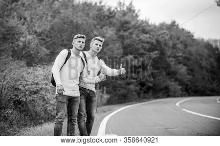Travellers On Their Way. Friends Hitchhikers Travelling. Hitchhiking Gesture. Begin Great Adventure 