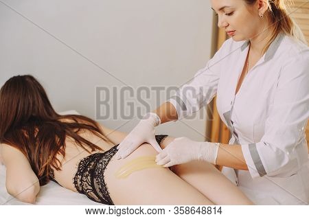 Beautician Removes Hair From Womens Legs. Wax Shugaring. Beautiful Girl Master Does Depilation In Th