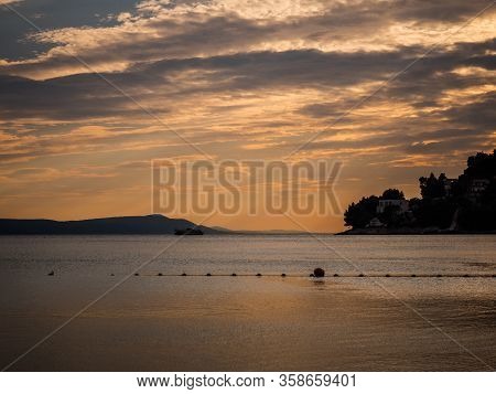 Sunset Over The Mediterranean Sea In Drvenik, Croatia And Boat Sailing To The Port.