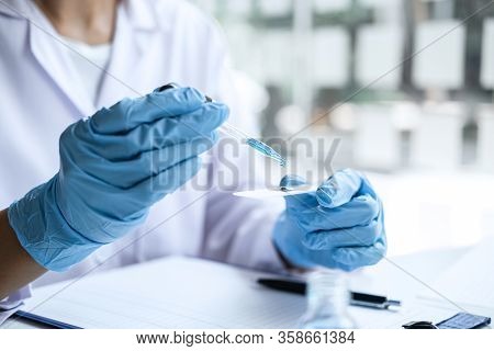 Scientist Or Medical In Lab Coat Holding Test Tube With Reagent, Mixing Reagents In Glass Flask, Gla