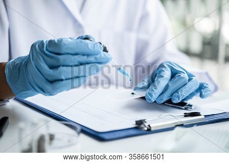Scientist Or Medical In Lab Coat Holding Test Tube With Reagent, Mixing Reagents In Glass Flask, Gla