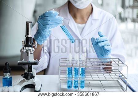 Biochemistry Laboratory Research, Scientist Or Medical In Lab Coat Holding Test Tube With Using Micr