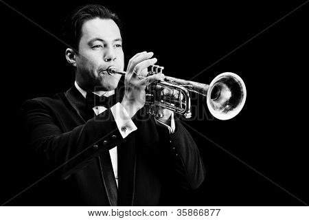 Retrato de um músico tocando a trombeta. Fundo preto.