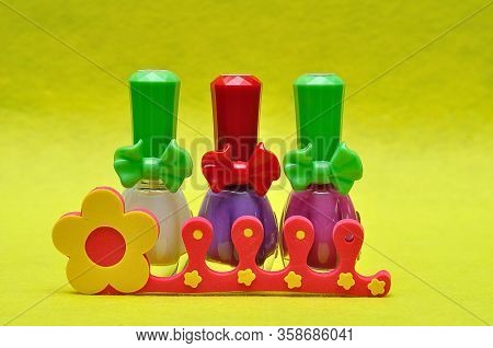 A Row Of Different Color Nail Polish With A Toe Separator