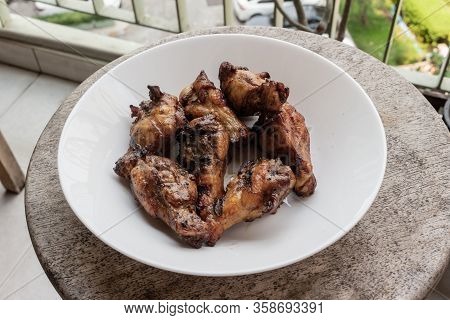 Delicious Portion Of Grilled Chicken Legs Served In A White Plate