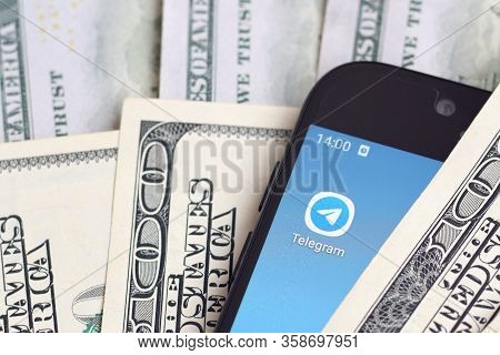 Smartphone Screen With Telegram App And Lot Of Hundred Dollar Bills. Business And Social Networking 