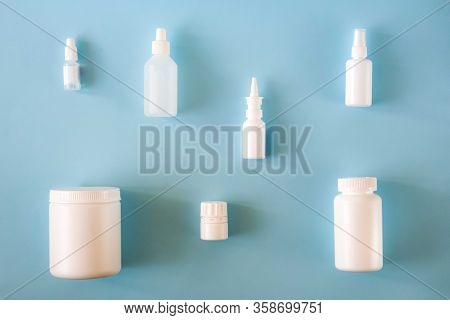 Various White Plastic Medical Containers Set On Light Blue Background. Virus Or Flu Or Cold Treatmen