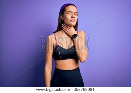 Young beautiful sporty girl doing sport wearing sportswear over isolated purple background Touching painful neck, sore throat for flu, clod and infection