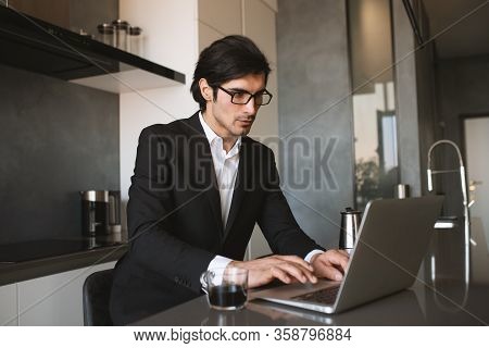 Businessman Works From Remote At House With A Laptop Due To Coronavirus Quarantine.