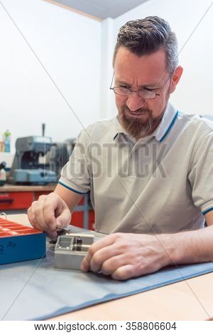 Lockmith working on a lock repairing it, close-up