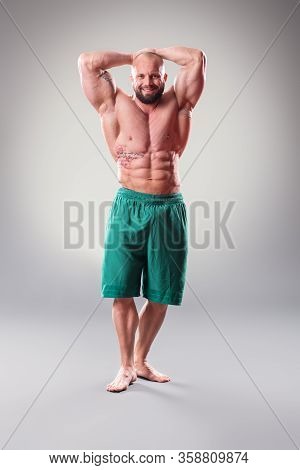 Sexy Muscular Bodybuider Posing On The Gray Background