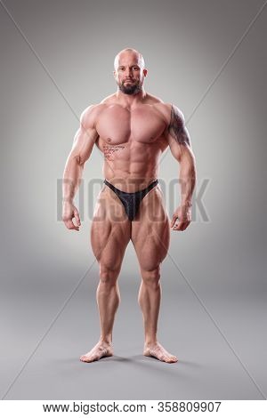 Sexy Muscular Bodybuider Posing On The Gray Background