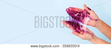 Young Girl Hands With Sticky Purple Slime On Blue Background, Liqiud Wax For Depilation, Conceptual 