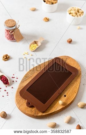 Homemade Dark Chocolate Bar In Mold With Dried Berries And Nuts On White Background. Side View. Choc