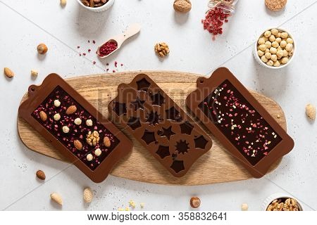 Homemade Chocolate Bars With Nuts And Dried Fruits In Molds. Chocolatier, Confectionery. Top View