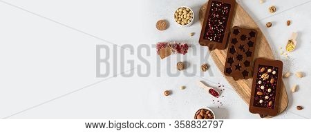 Chocolate Banner. Dark Chocolate Bars And Candies In Molds With Nuts And Dried Fruits On White Backg