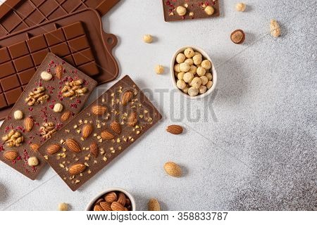 Homemade Milk Chocolate Bars And Molds. Chocolate Bars, Nuts, Dried Fruits On Gray Background Top Vi